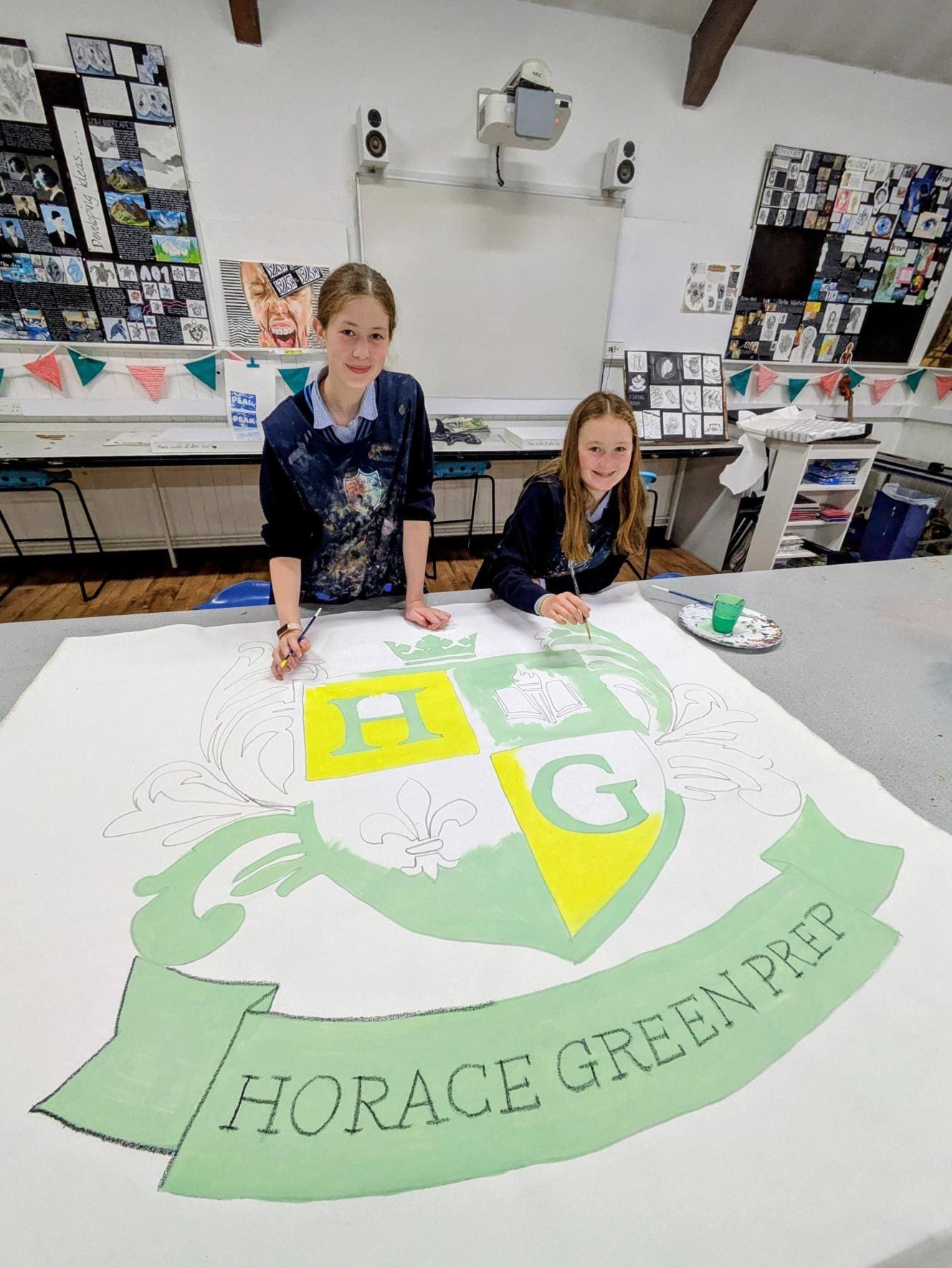 Art students at Windermere School played a vital role in bringing the School of Rock production to life, working behind the scenes to transform creative ideas into vibrant stage magic. From wallpaper-pasting, to painting large-scale banners and crafting the detailed set, their efforts could be spotted in every corner of the stage in Crampton. The production was a fantastic collaboration between Drama, Music, and Art—to create a show that truly rocked.